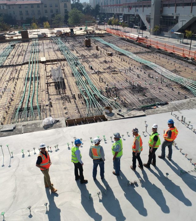 seven construction workers standing on white field